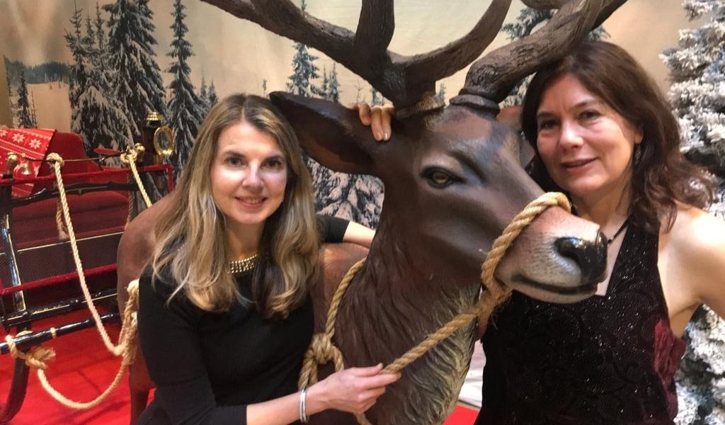 Merel Huizinga en Dess bij een rendierbeeld in een kerstdecor