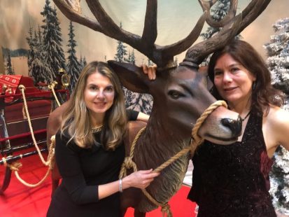 Merel Huizinga en Dess bij een rendierbeeld in een kerstdecor